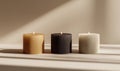 Three round candles of different colors are lit and placed in a row on a neutral background Royalty Free Stock Photo