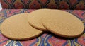 Three round cork coasters are placed on an ornate surface. The coasters have a Royalty Free Stock Photo