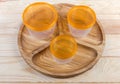 Three round plastic food storage containers on wooden compartmental dish