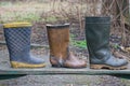 three rubber boots stand on a wooden table Royalty Free Stock Photo