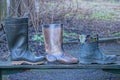 three rubber boots stand on a wooden table Royalty Free Stock Photo