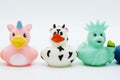 Three rubber ducks, a cow statue of liberty and penguin on an isolated white background Royalty Free Stock Photo
