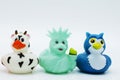 Three rubber ducks, a cow statue of liberty and penguin on an isolated white background