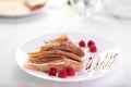 Three Russian thin pancakes and crepes folded triangle with raspberries, caramel sauce and chocolate chips