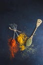 Three rustic teaspoons with spices on dark background. Top view. Royalty Free Stock Photo