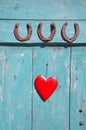 Three rusty horseshoe luck symbol and red heart on door Royalty Free Stock Photo
