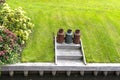 Three rusty metal milk canisters standing on the edge of the canal in the lawn.