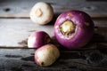 Three rutabaga lying on rustic wood background.