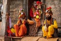 Three Sadhu dressed in saffron colored clothes sits in ancient votive shrine of Pandra Shivalaya Royalty Free Stock Photo