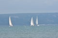 Three sailboats in coastal waters Royalty Free Stock Photo