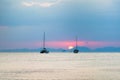 Three sailing yachts in the sea. During sunset, the sun sets over the mountains Royalty Free Stock Photo