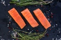Three salmon steakes with thyme, rosemary, pepper and salt grains