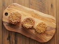 Three salted caramel doughnut with golden crumb on a wooden board and table