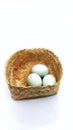 Three salted duck eggs in a woven bamboo container