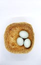 Three salted duck eggs in a woven bamboo container