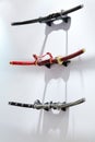 Three samurai swords hang on white wall
