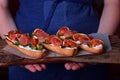 Three sandwiches with figs, smoked ham, arugula and soft cheese on a wooden board Royalty Free Stock Photo