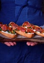 Three sandwiches with figs, smoked ham, arugula and soft cheese on a wooden board Royalty Free Stock Photo