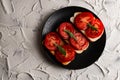 Three sandwiches with fresh and bright red tomatoes and smoked sausage, decorated with a leaf of green arugula Royalty Free Stock Photo