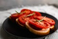 Three sandwiches with fresh and bright red tomatoes and smoked sausage, decorated with a leaf of green arugula Royalty Free Stock Photo