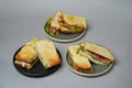 Three sandwiches with ham and vegetables on grey background Royalty Free Stock Photo