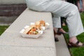 Three sandwiches in to-go cartons on a concrete ledge