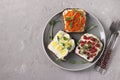 Three sandwiches on toast with cream cheese, carrots, red currant and quail eggs decorated with microgreens peas on a plate on