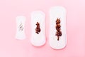 Three sanitary pads on pink background