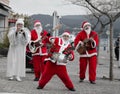 Three Santa Clauses Making Music