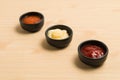 Three sauce in black bowl on wood background