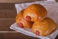 Three sausage breads on white linen