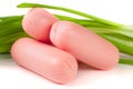 Three sausages with spring onions isolated on white background closeup Royalty Free Stock Photo