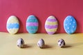 Three sawn eggs in the foreground and four cookies-eggs on a pink background Royalty Free Stock Photo