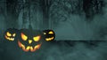 Three scary glowing pumpkins on a wooden table in a night forest with fog and bats in the dark. Happy halloween creative Royalty Free Stock Photo