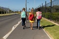 Three schoolgirls walking along a road to elementary school