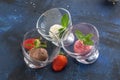 Three scoops of chocolate, strawberry and vanilla ice cream in glass bowl on blue background Royalty Free Stock Photo