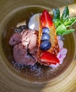 Three scoops of colorful ice cream with fresh strawberries, blueberries and fresh mint leaves Royalty Free Stock Photo