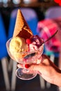 Three scoops of ice cream with a waffle cone in a glass on a blurred background Royalty Free Stock Photo