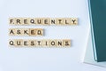 FAQS or Frequently asked questions word made with building blocks isolated on white. Wooden blocks with the word FAQ