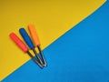 Three screwdrivers of different colors vertically on a yellow and blue background with a copy of the space. Royalty Free Stock Photo