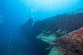 Scuba divers simming near a shipwreck under the sea Royalty Free Stock Photo
