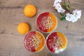 Three semolina pudding cups with fruit coulis and chopped nuts on top