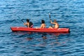 Three senior adults kayaking in the blue sea - Liguria Italy Royalty Free Stock Photo