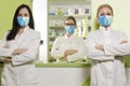 Three serious female pharmacists with protective clothes