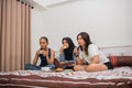 three serious women watching horror movies and eating on the bed Royalty Free Stock Photo