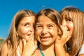 Three seven year old girls playing and whispering Royalty Free Stock Photo