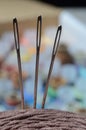 Three sewing needles are inserted into a spool of thread. close-up. Royalty Free Stock Photo