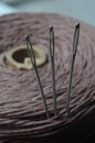Three sewing needles are inserted into a spool of thread. close-up. Royalty Free Stock Photo