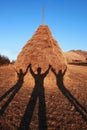 Three shadows holding hands on haystack