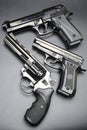 Three shiny black pistols on a black background